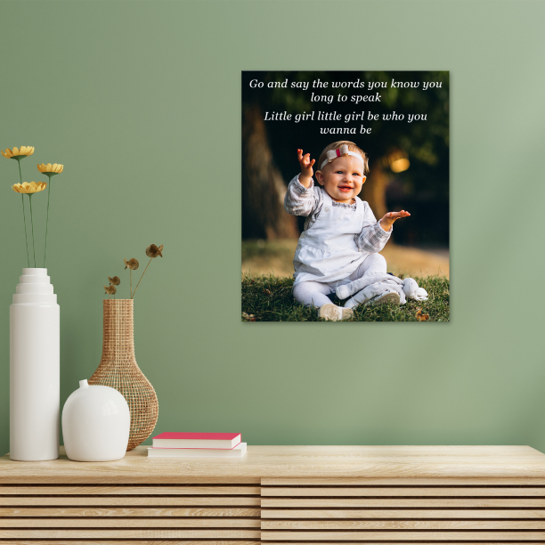 Canvas print of a smiling toddler sitting on grass, with an empowering quote above her