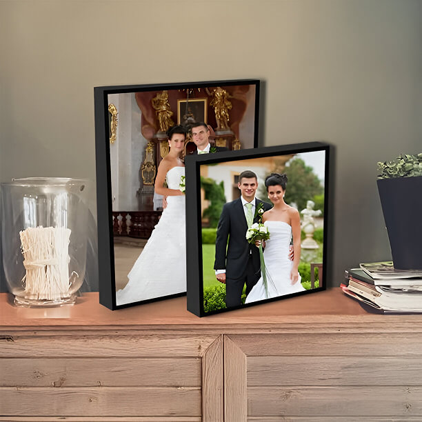 Framed wedding photos of a bride and groom displayed on a wooden cabinet.